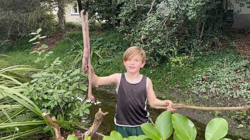 Barnaby Domigan with the giant worm he found in his backyard.