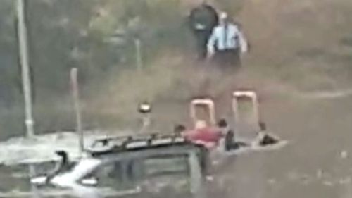 NSW Police rescue man from ute stuck in floodwaters.