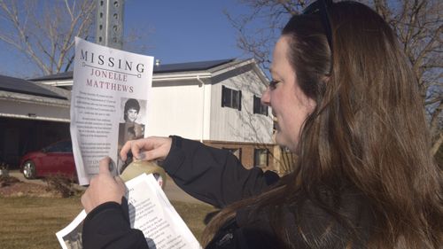 In this December 2018 photo, a victims advocate in Greeley, Colorado posts a flyer of a missing persons poster for Jonelle Matthews.