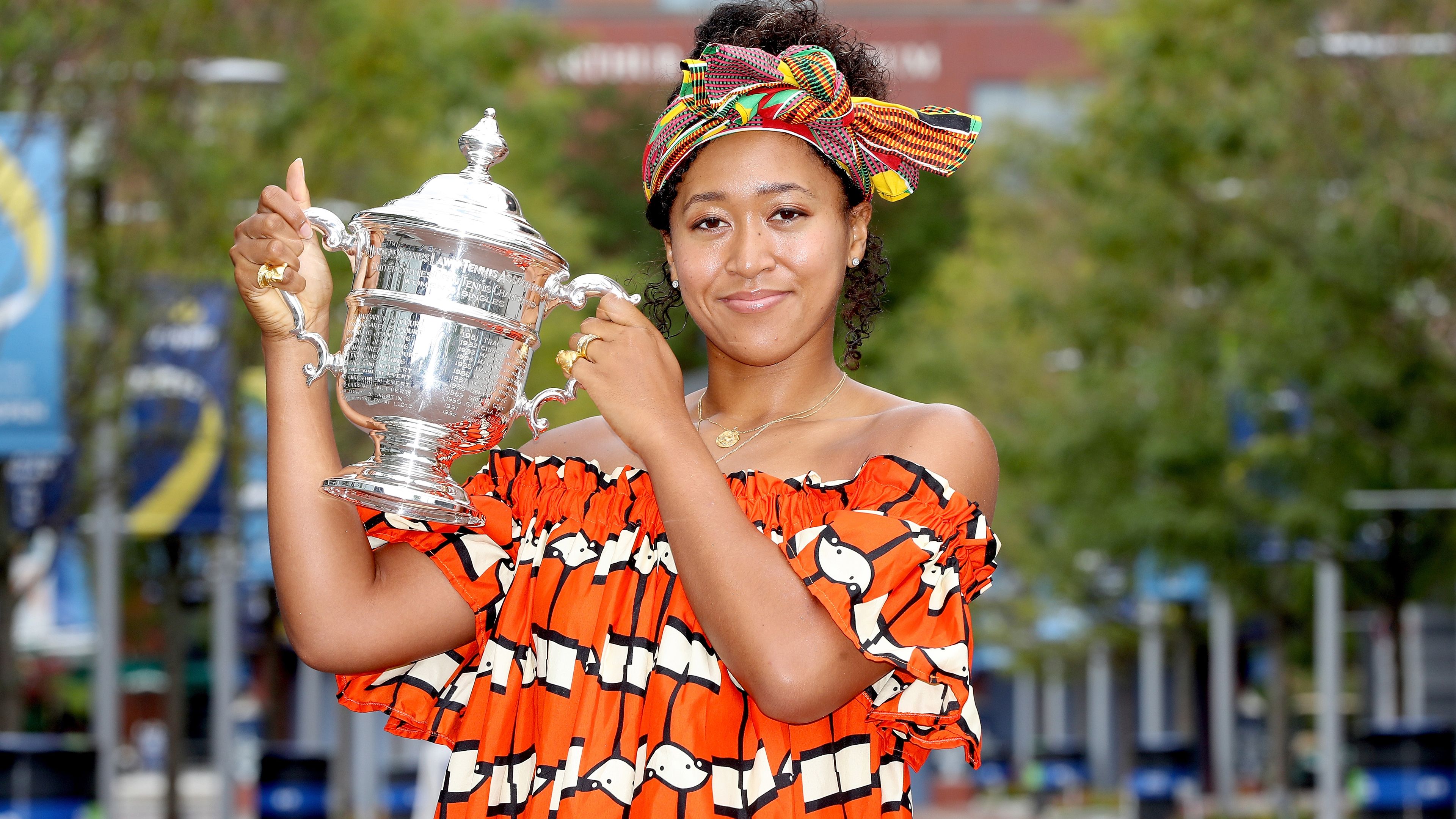 Naomi Osaka poses for photos with the US Open trophy.