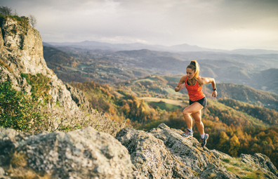 Woman athlete running up mountain