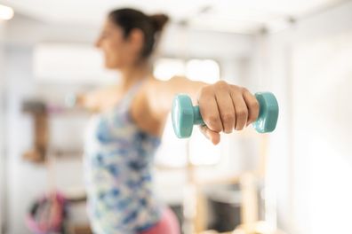 Sportswoman holding dumbbells.