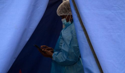A healthcare worker waits to test people for 'COVID-19 at a facility in Soweto, South Africa