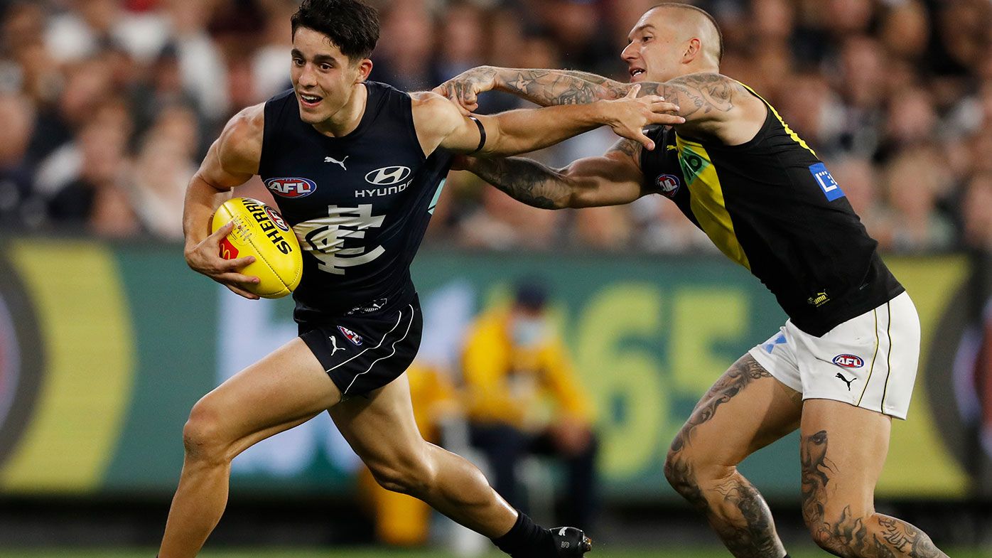  Adam Cerra of the Blues fends off Dustin Martin