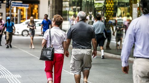 Two old people walk down the street in Brisbane