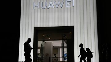 Shoppers pass by a Huawei store in Beijing, China, Thursday, Aug. 26, 2021.  