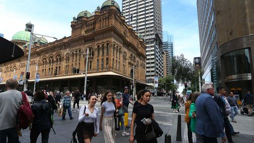 Pietoni în afara clădirii Queen Victoria din Sydney.