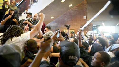 People chant 'we want justice' inside Kensington Town Hall. (AAP)