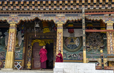 A senior and junior monk chat during break time at Tashichho Dzong in Bhutan.