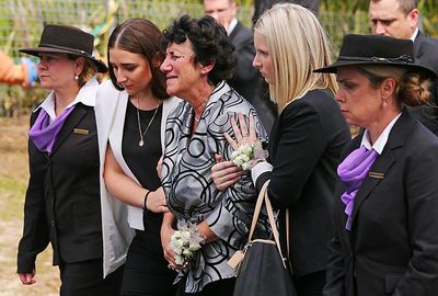 Hughes' mother, Virginia Hughes, with daughter Megan Hughes (L) follows behind the coffin.