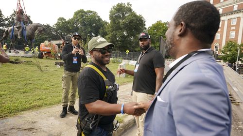 Devon Henry, left, was the owner of the construction company that removed the statue shook hands with Richmond Mayor, Levar Stoney, right. 