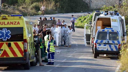 An ambulance is parked along the road where a car bomb exploded killing investigative journalist Daphne Caruana Galizia.