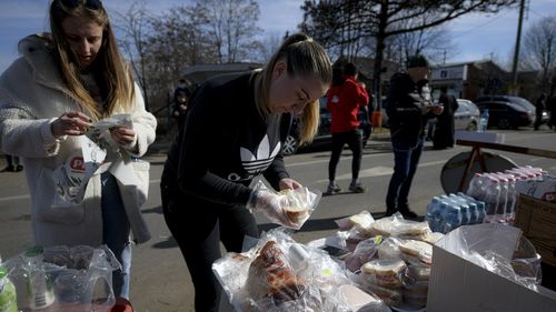Volunteers prepare sandwiches for refugees crossing the border from Ukraine at the Romanian-Ukrainian border, in Siret, Romania.