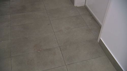 Blood could be seen on tiles outside a unit in the building.