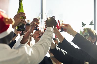 Close-up group of corporate executives raising their glasses to toast their success at year-end.