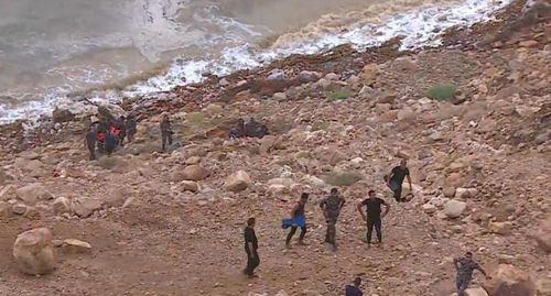 At least 18 people have been killed after flash floods swept away a group of teachers and students visiting hot springs near the Dead Sea.