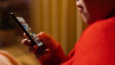 Woman using phone in front of the TV