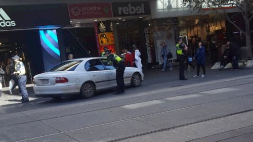 Police quickly swarmed the car after it allegedly 'took a wrong turn' down Bourke Street Mall. 