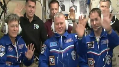 NASA astronaut Peggy Whitson, Oleg Novitskiy of the Russian space agency Roscosmos, and Frenchman Thomas Pesquet of the European Space Agency, wave after docking at the International Space Station. (AFP / NASA TV)