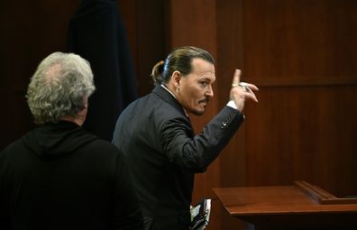 Actor Johnny Depp gestures as he walks out of the courtroom during a break at the Fairfax County Circuit Courthouse in Fairfax, Va., Tuesday, May 17, 2022. 