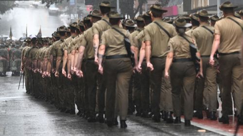 Des membres des Forces de défense australiennes (ADF) défilent lors d'un défilé de l'Anzac Day le 25 avril 2022 à Brisbane, en Australie