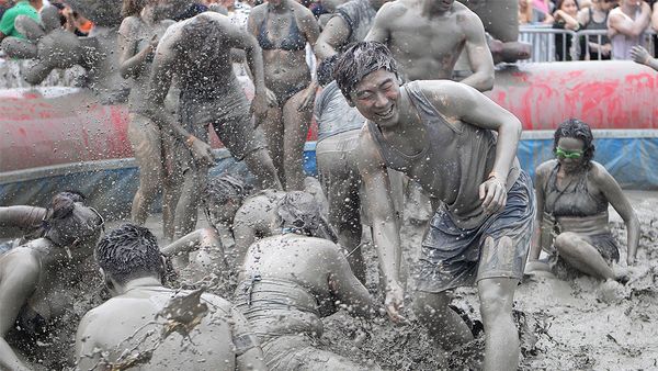 People covered in mud during Boryeong Mud Festival (Getty)