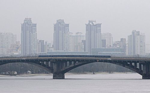 Поезд метро проезжает по мосту через реку Днепр в Киеве, Украина, пятница, 11 ноября 2022 г.