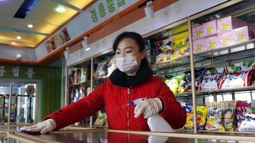 An employee of the Kyonghung Foodstuff General Store disinfects the showroom countertops in Pyongyang, North Korea in November 2021.
