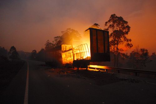  The remains of a truck is left to burn on the Pacific Highway after a fire in Hillville closed the highway.