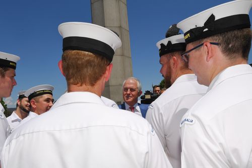 Mr Turnbull speaks to naval officers after the announcement of the winning bid to build the offshore patrol vessels. (AAP)