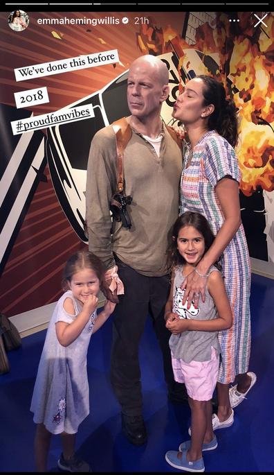 Emma Heming Willis poses besides Bruce Willis' wax figure with their two children, Mabel and Evelyn