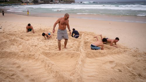 Two families build a Star of David at Bondi Beach, two days after a mass shooting, on December 16, 2025 in Sydney, Australia.