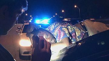 The unconscious man fast asleep on the boot of a car. (Memphis Police)