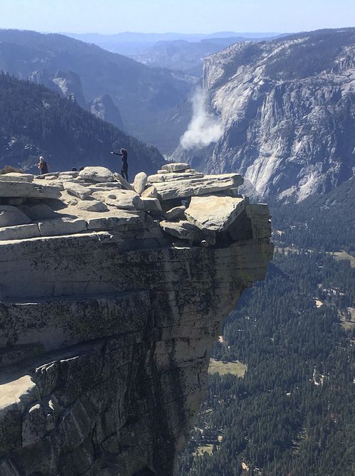 A cloud of dust is seen in the distance on El Capitan after a major rock fall in Yosemite National Park, Calif. (John P. DeGrazio/YExplore Yosemite Adventures via AP)