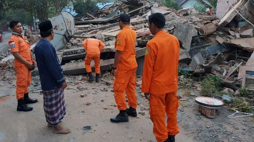 Rescuers inspecting collapsed houses after the earthquake struck in Bali and Lombok.