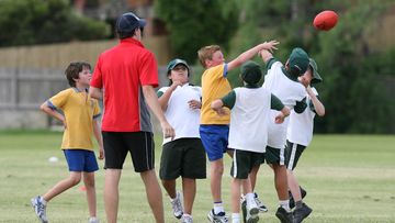 Under 9 and under 10 school children playing AFL