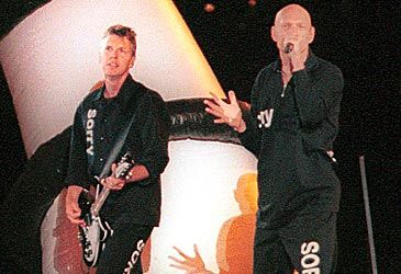 Which song did Midnight Oil play at the closing ceremony wearing "sorry" clothing?