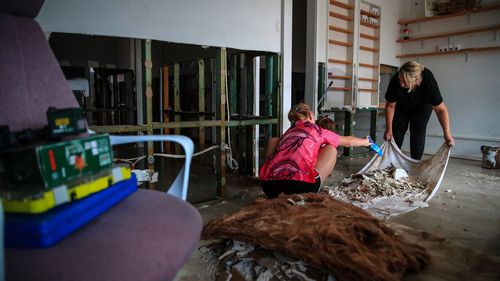 TAREE, AUSTRALIA - MAY 23: Business owners clean their shop following a flood at Albert street on May 23, 2025 in Taree, Australia. Catastrophic flooding struck the Mid North Coast and other parts of New South Wales, isolating over 50,000 residents, prompting hundreds of rescues, and leaving at least one person dead and several missing as emergency services responded to record-breaking rainfall. (Photo by Roni Bintang/Getty Images)