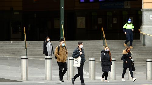 People in front of Flinders Street Station in Melbourne, Australia. Face masks or coverings will be mandatory from Thursday 23 July, with $200 fines in place.