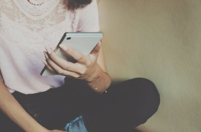 Young woman sitting looking at phone