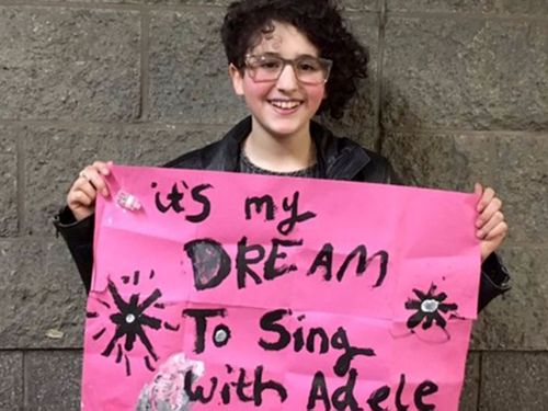 Emily Tammam with the sign Adele noticed in the crowd. (Twitter)