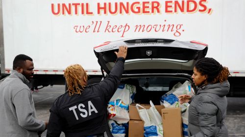 Federal workers who have missed their pay checks stock up on essentials at a food bank in Maryland.