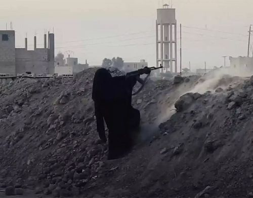 A scene from a recent Islamic State propaganda video appearing to show a black-robed woman fighting in Syria.