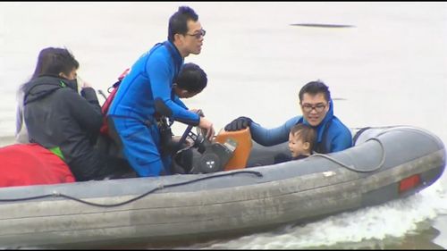 Rescued passengers are taken to shore for transport to local hospitals.