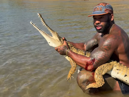 A popular American influencer is facing a fine after posting a video of himself grabbing a crocodile in ï»¿Far North Queensland. 