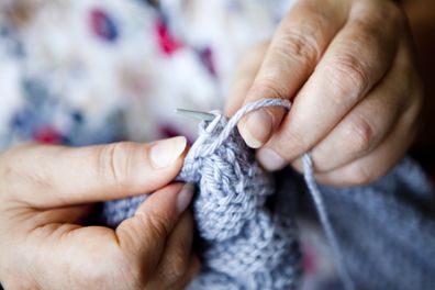 Close-up view of hands knitting.