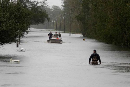 A member of the U.S. Coast Guard walks down Mill Creek Road checking houses after tropical storm Florence hit Newport, North Carolina. 