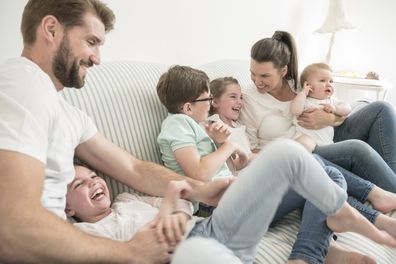 Family at home with four children having fun together, laughing and smiling