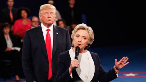 Democratic presidential nominee former Secretary of State Hillary Clinton speaks as Republican presidential nominee Donald Trump listens during the town hall debate at Washington University on October 9, 2016 in St Louis, Missouri. (Getty)