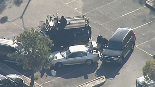 Specialist police surround the vehicle. (9NEWS)